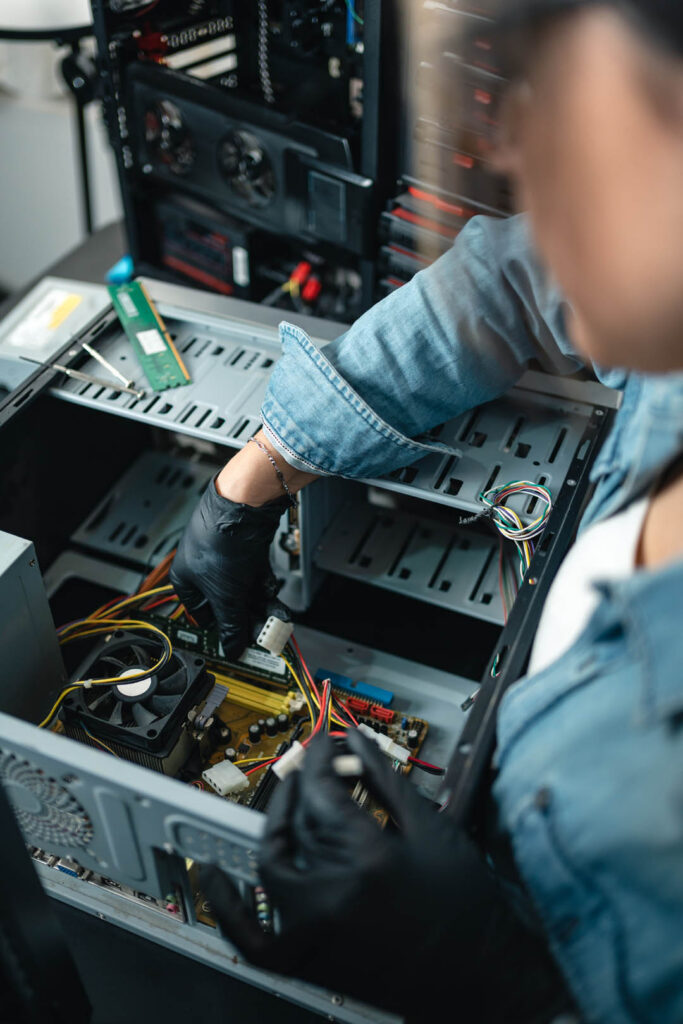 Close up of woman fixing hardware of desktop computer. Vertical photography. Selective focus